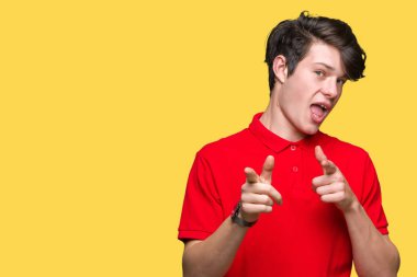 Fotoğraf makinesi ile mutlu ve komik yüz için parmakları işaret izole arka plan üzerinde kırmızı t-shirt giyen genç yakışıklı adam. İyi enerji ve vibes.