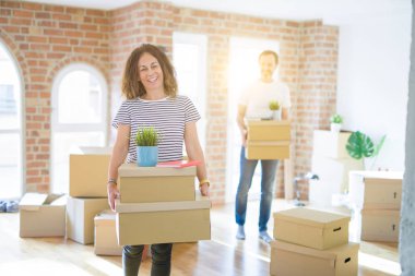 Orta yaş yaşlı çift yeni bir eve hareketli, gülümseyen kadın ho