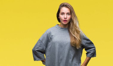 Genç güzel sarışın kadın izole arka plan korkuyor ve sürpriz ifade ile şok yüzünden korku ve yüz heyecanlı.