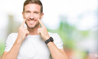 Casual beyaz t-shirt gülen ile giyen yakışıklı adam açık ağız, işaret ve neşeli zorla parmak gülümse