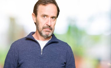 Orta yaş yakışıklı adam bir kazak şüpheci ve sinir, sorun nedeniyle üzgün çatık giyiyor. Negatif kişi.