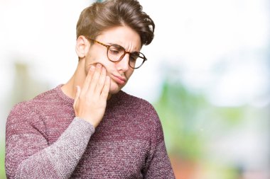 Diş ağrısı veya dişlerde dişlerle ilgili hastalık nedeniyle ağız acı ifadesi ile el ile dokunmak izole arka plan üzerinde gözlük takan yakışıklı delikanlı. Diş hekimi kavramı.