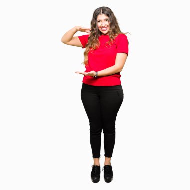 Büyük ve büyük boy işaret, ölçü birimi sembol gösteren elleriyle işaret rahat t-shirt giyen genç güzel kadın. Kameraya bakarak gülümsüyordu. Ölçüm kavramı.