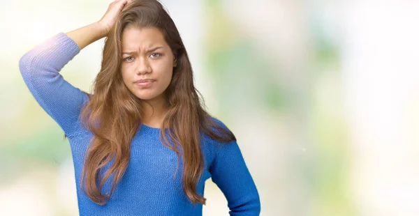 Young beautiful brunette woman wearing blue sweater over isolated background confuse and wonder about question. Uncertain with doubt, thinking with hand on head. Pensive concept.