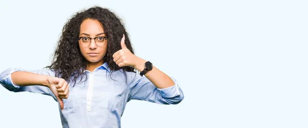眼鏡をかけている巻き毛の若い美しいビジネス女の子は 意見の不一致と合意表現を親指をしています クレイジー紛争 — ストック写真