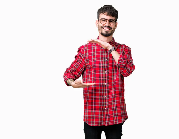 Mladý Pohledný Muž Nosí Brýle Izolované Pozadí Gestikuloval Rukama Ukazuje — Stock fotografie