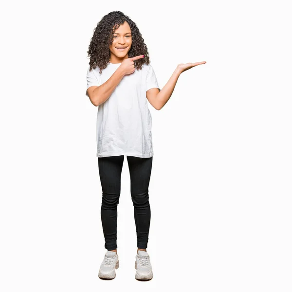 Jonge Mooie Vrouw Met Krullend Haar Dragen Wit Shirt Verbaasd — Stockfoto