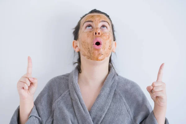 Schöne Junge Frau Trägt Kosmetische Gesichtsmaske Als Hautpflege Schönheitsbehandlung Erstaunt — Stockfoto