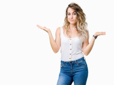 Genç güzel sarışın kadın izole arka plan clueless ve şaşkın bir ifadeyle kollar ve eller kaldırdı. Şüphe kavramı.