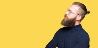 İkna ve kendine güvenen genç sarışın adamın gözlük ve yan kolları ile seyir gülümseyen boğazlı kazak giydiğini geçti