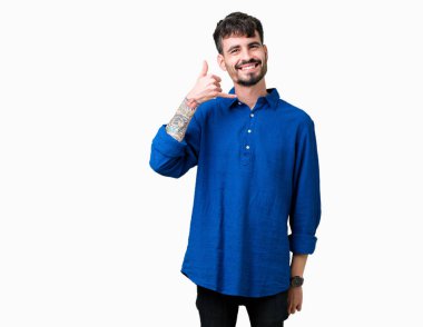 Yakışıklı delikanlı yapıyor gülümseyen izole arka plan üzerinde telefon hareketi ile el ve parmak telefonda konuşuyor gibi. Kavramları iletişim.
