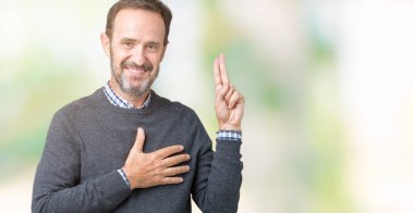 Bir kazak izole üzerinde giyen yakışıklı orta yaş üst düzey adam arka plan Swearing göğüs ve parmaklar, el ile bir sadakat sözü yemin yapma