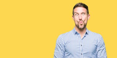 Mavi gözlü yakışıklı iş adamı dudaklar, çılgın ve komik jest ile balık yüzü yapıyor. Komik ifade.