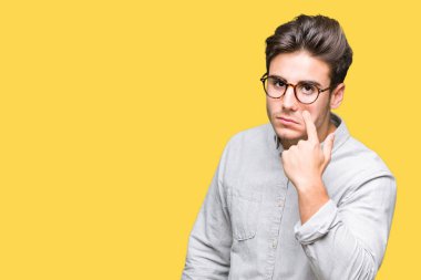 Genç yakışıklı adam gözlük izole üzerinde arka plan işaret jest göz izlemek için şüpheli ifade