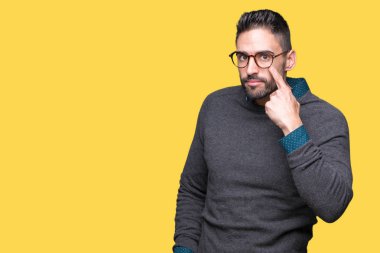Genç yakışıklı adam gözlük izole üzerinde arka plan işaret jest göz izlemek için şüpheli ifade