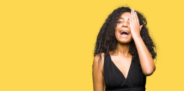 Kıvırcık saçlı Genç güzel kız yüz ve sürpriz duygu kendine güvenen gülümseme ile el ile bir göz kaplayan moda etek giyiyor.