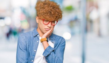 Yakışıklı delikanlı afro saçlı gözlüklü seyir yorgun ve çapraz kolları olan depresyon sorunları ile sıkılmış düşünme.