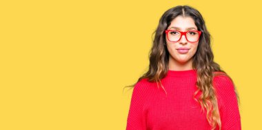 Yüzünde ciddi bir ifade ile kırmızı gözlük takan genç güzel kadın. Basit ve doğal kameraya bakıyor.