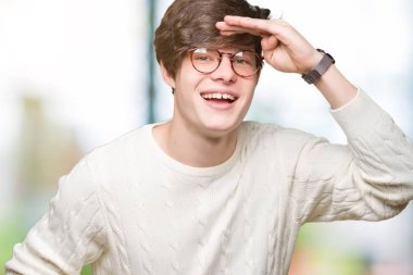 Üzerinde gözlük takan genç yakışıklı adam arka plan çok mutlu ve gülümseyen uzakta el ile üzerine kafa seyir izole. Arama kavramı.