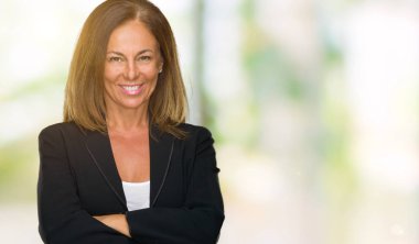 Güzel orta yaş iş yetişkin kadın izole arka plan mutlu yüz çapraz silah kameraya bakarak ile gülümseyen yüzünden. Olumlu bir kişi.