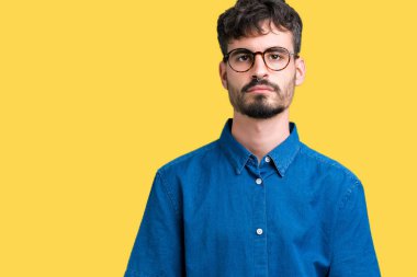 Üzerinde gözlük takan genç yakışıklı adam arka plan gevşek yüzünde ciddi bir ifade ile izole. Basit ve doğal kameraya bakıyor.
