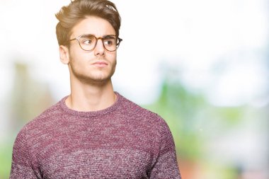 Yakışıklı delikanlı görünümlü yan ve dik dik bakma uzağa düşünce gülümseyen izole arka plan üzerinde gözlük.