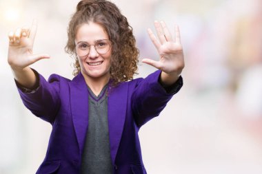 Genç esmer öğrenci kız giyiyor okul üniforması ve gözlük gösterilen ve parmakları ile işaret izole arka plan üzerinde kendinden emin ve mutlu gülümseyerek süre yedi numara.