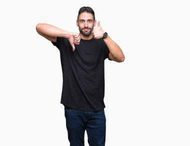 Yakışıklı delikanlı izole arka plan yapmaya başparmak yukarı ve aşağı, anlaşmazlık ve anlaşma ifade üzerinde. Deli çatışma