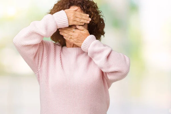 Pembe kazak ve güneş gözlüğü izole arka plan kaplaması gözler ve ağız el ile üzerinden giyen güzel orta ager üst düzey kadın şaşırttı ve şok. Duygu gizleme