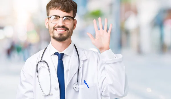 年轻的医生男子穿着医院外套在孤立的背景显示和手指指向五 同时微笑着自信和快乐 — 图库照片