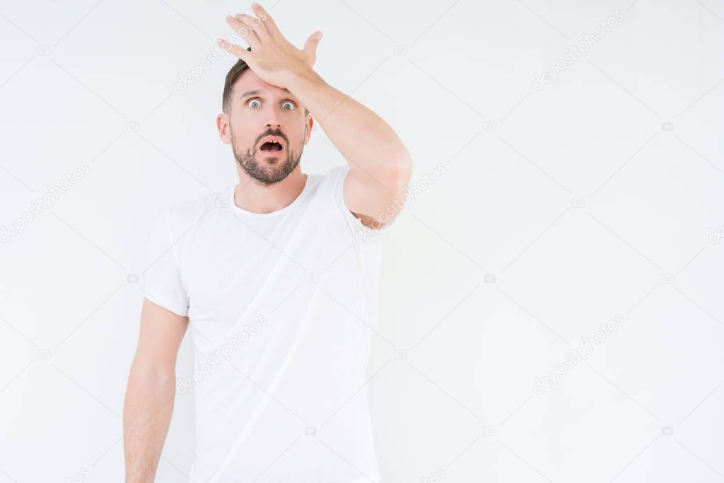 Young handsome man wearing casual white t-shirt over isolated background surprised with hand on head for mistake, remember error. Forgot, bad memory concept.