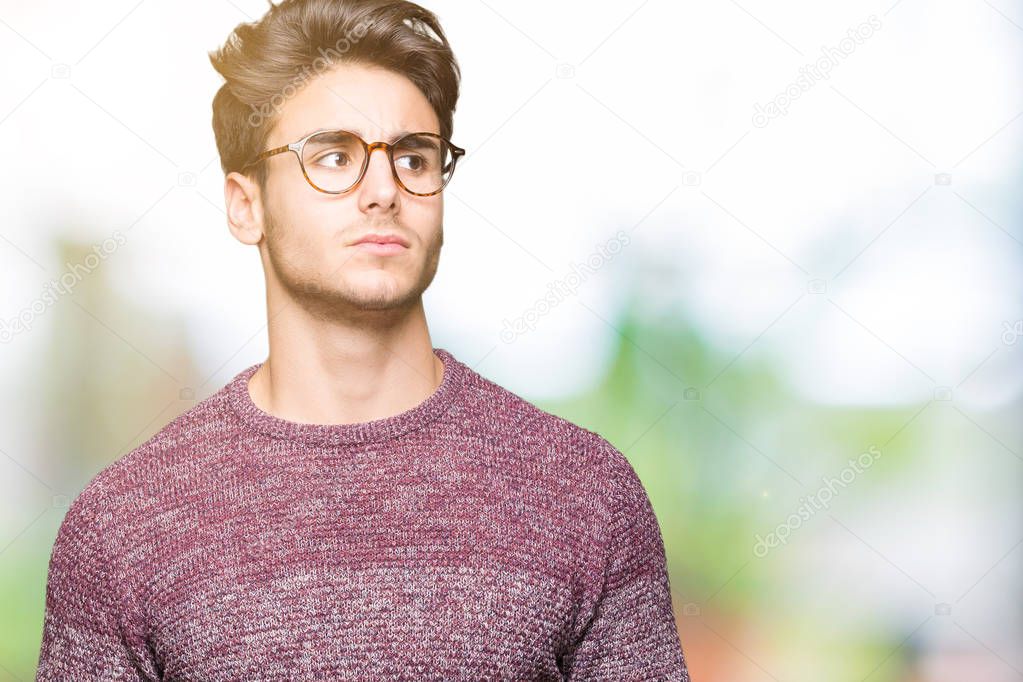 Young handsome man wearing glasses over isolated background smiling looking side and staring away thinking.