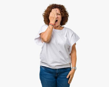 Yarım yüz, göz ve ağız el ile kapsayan Yawning yorgun arka plan üzerinde beyaz t-shirt giyen kadın güzel orta ager kıdemli izole. Acı yüzü acıyor.