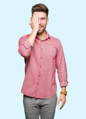 Genç yakışıklı iş casual adam yüz ve sürpriz duygu kendinden emin gülümseme ile el ile bir göz kapsayan.