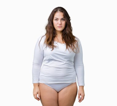 Artı boyutu genç overwight kadın güzel üzerinde beyaz iç çamaşırı giyiyor arka plan gevşek yüzünde ciddi bir ifade ile izole. Basit ve çapraz silah ile doğal