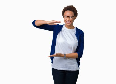 Büyük ve büyük boy işaret, ölçü birimi sembol gösteren ellerle eller izole arka plan üzerinde gözlük takan genç güzel Afrikalı-Amerikalı kadın. Kameraya bakarak gülümsüyordu. Ölçüm kavramı.