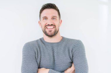 Mutlu yüz ile gülümseyerek kameraya seyir silah geçti arka plan üzerinde rahat kazak giyen genç yakışıklı adam izole. Olumlu bir kişi.