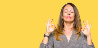 Güzel orta yaş iş kadın dinlenmek ve gözleri ile gülümseyen meditasyon jest parmaklar ile kapalı. Yoga konsepti.