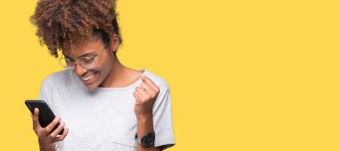 Duygu tezahürat gurur çığlık ve zafer ve başarı çok heyecanlı, kutluyor izole arka plan üzerinde akıllı telefon kullanan genç Afro-Amerikan kadın