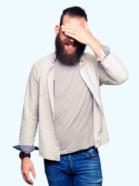 Gülümsüyor ve gözleri için sürpriz kapsayan yüz el ile gülüyor gözlüklü genç sarışın adam. Kör kavramı.