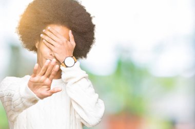 Kış kazak kapsayan giyen afro saçlı genç Afro-Amerikan adam gözleri ile el ve stop jest ile acı ve korku ifadesi. Utandım ve negatif kavramı.