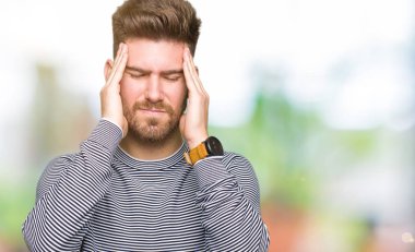 Genç yakışıklı adam kafa ağrısı için başını el ile çizgili kazak giyiyor çünkü stres. Acı çeken migren.