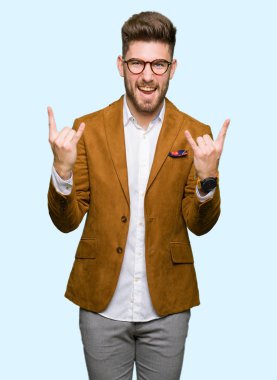 Genç yakışıklı iş adamı deli ifade rock simge elle yapıyor ile bağırarak gözlük takıyorum. Müzik yıldızı. Ağır kavramı.