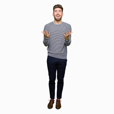 Yakışıklı delikanlı giyen kazak deli çizgili ve deli bağırarak ve agresif ifade ve silah kaldırdı bağırıyor. Hayal kırıklığı kavramı.