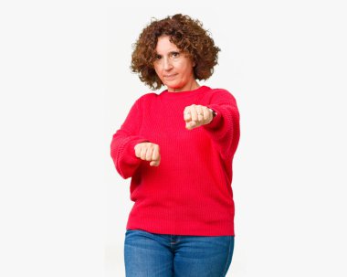 İzole arka plan üzerinde güzel orta ager kıdemli kadın kırmızı kış kazak mücadele, agresif ve öfkeli saldırı, tehdit ve şiddet yumruk Punch