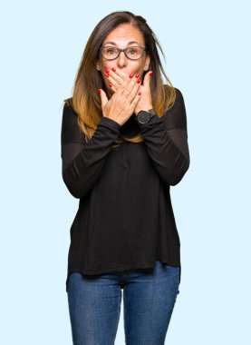 Gözlük giyen güzel orta yaş kadın hata elleri ile ağız kapsayan şok. Gizli konsept.