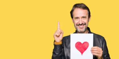 Bir fikir ya da soru işaret parmağı ile gülen yüz, bir numara kırmızı kalp ile kağıt tutan yakışıklı orta yaş adam şaşırttı