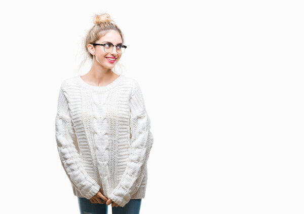 Young beautiful blonde woman wearing glasses over isolated background looking away to side with smile on face, natural expression. Laughing confident.