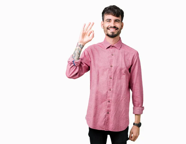 年轻英俊的男子穿着粉红色的衬衫在孤立的背景微笑积极做确定的迹象与手和手指 成功的表达 — 图库照片
