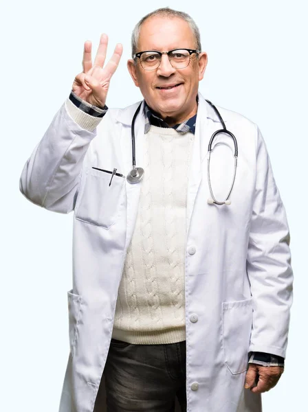 自信を持って幸せそうに微笑みながら 医療コートを着たハンサムな先輩医師男性が指で3番を指差し上げる — ストック写真